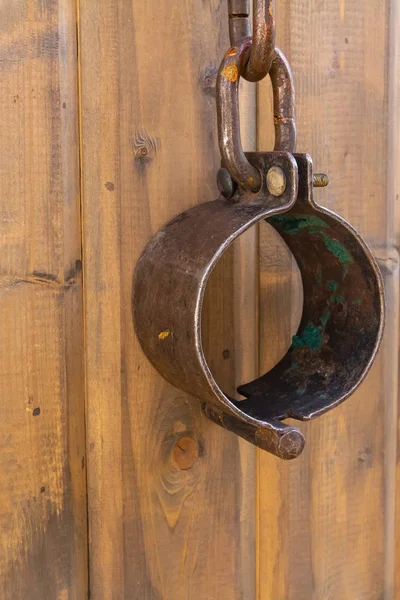 Closeup metal shackles vertical photo on wooden wall. The arrest of the criminal handcuffed shackle — Stock Photo, Image