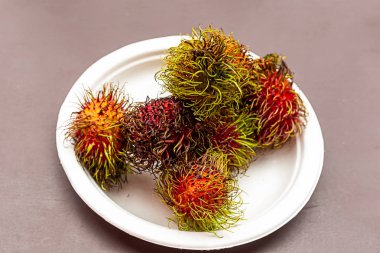 beyaz bir tabak üzerinde rambutan kırmızı olgun tropikal meyve Tay tatlı