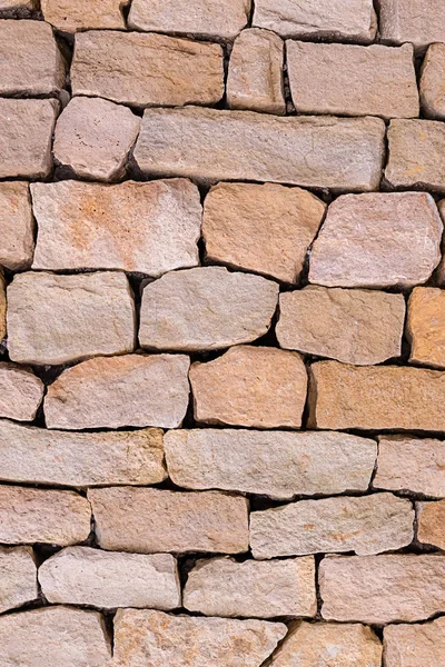 stone wall beige cobblestones uneven vertical photo weathered natural background