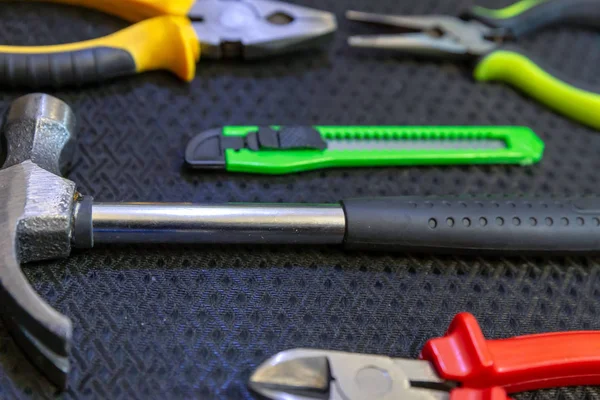 Hammer kniv grønne nippers lukke grå baggrund arbejde værktøj - Stock-foto