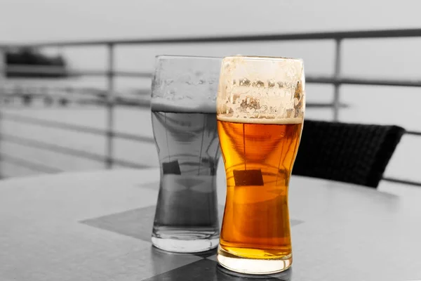 Piwo szklanka lager złoty kontrast jeden z wielu szare tło ulica kawiarnia — Zdjęcie stockowe