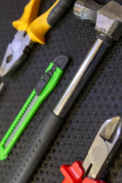 Kit de herramientas conjunto vertical martillo pinzas cuchillo verde primer plano fondo — Foto de Stock
