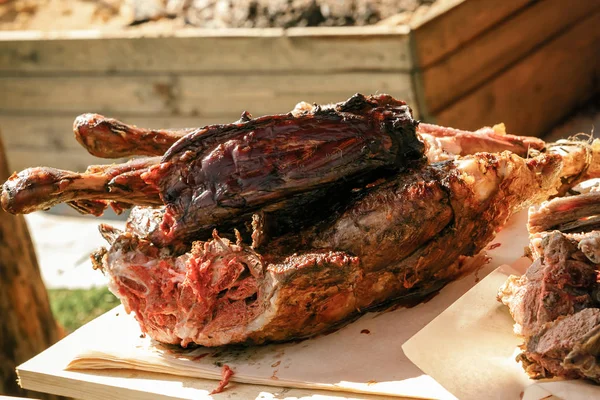 baked large piece of wild boar meat on a cutting wooden board