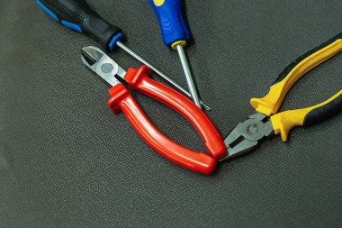 nippers kauçuk kolları kırmızı mavi tornavida koyu arka plan masaüstü tamir alet kiti