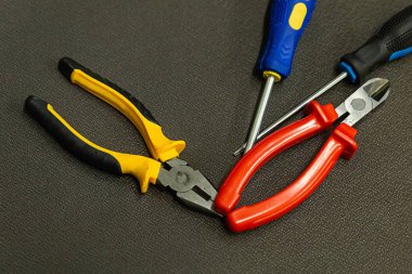 El aleti seti siyah turuncu çerçeveler ve koyu bir arka plan üzerinde kırmızı mavi tornavida yakın çekim oluşur