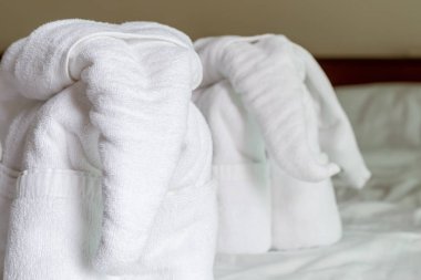 Beyaz bir fil figürü bir yatakta Asya'nın otel odasında bir tebrik beyaz beyaz yapılmış