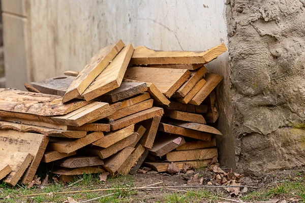 wooden boards pile of sawed materials pattern traditional material near the rock wall shed