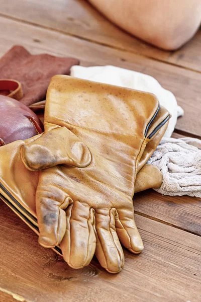 beige leather gloves, insulated hunting worn old on a wooden background