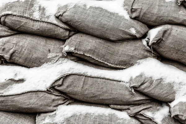 sand bag gray closeup background army closeup covered with snow protection storm