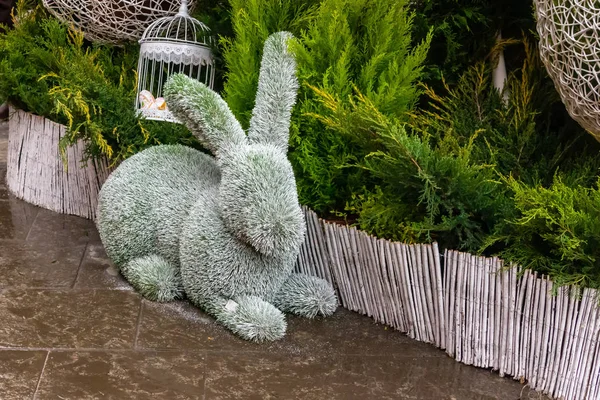 rabbit figure lay garden decor design easter park walkway on green bush background
