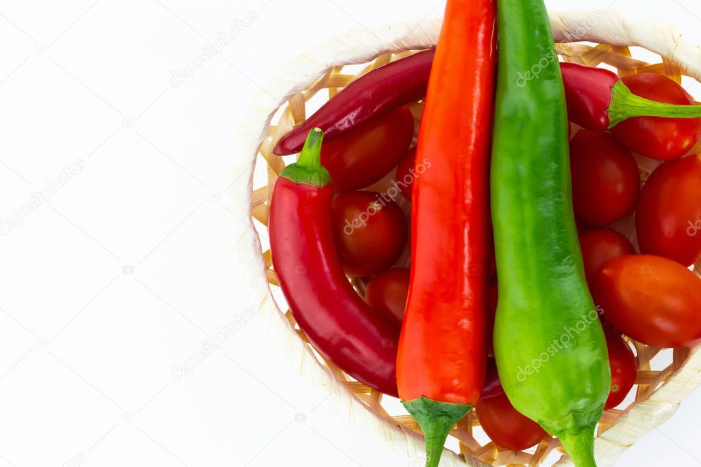 pair of peppers green red vertical pod basket tomatoes white isolated background copy space