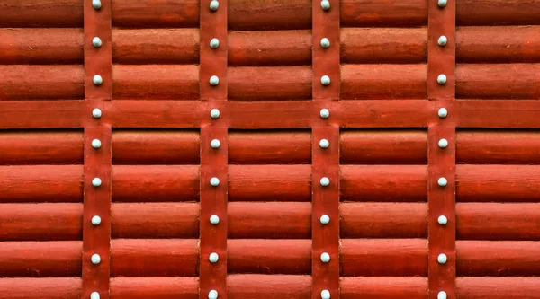Padrão vermelho de madeira feito de toros horizontais parede listras verdes verticais com rebites — Fotografia de Stock