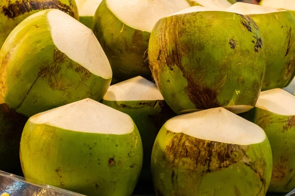 Čerstvé zelené kokosové partie z Asie, oloupané plody na hromadě thajských trhů — Stock fotografie