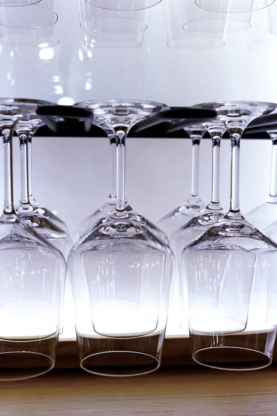 Set aus transparentem Weinglas, das gegenüber der glühenden Wand der Bar hängt — Stockfoto