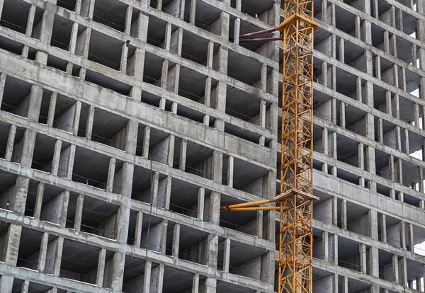 Bouwplaats bouw van een wolkenkrabber, cement basis met gele en ijzeren kraan close-up — Stockfoto