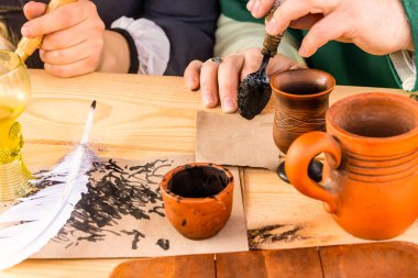 beyaz kalem geleneksel el yazısı aksesuarları ile bir mürekkep bir ahşap masa üzerinde durmak
