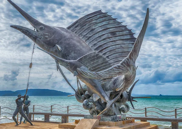 Thailand Krabi juli 2018. Standbeeld van de visserij. Paar vissers. Grote vis symbool van de stad Krabi op de achtergrond van de Oceaan — Stockfoto