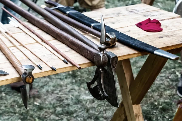 Conjunto de armas patrón de hacha guerrero medieval, espada en vaina y maza sobre fondo de mesa de madera — Foto de Stock