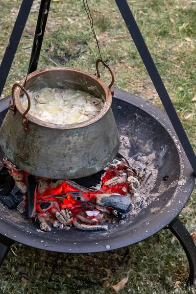 Bombín lleno de sopa preparada sobre un fuego cocinando en una fogata mientras acampaba — Foto de Stock