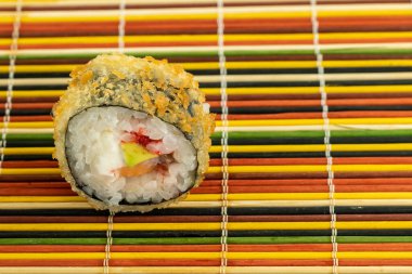 Somon ve krem peynirli tempura suşisi bambudan yapılmış sıcak ve lezzetli bir tabanda yatıyor.