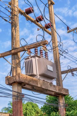 Yüksek voltajlı güç transformatörü dikey beton sütunlara monte edilerek elektrik alternatif akımının voltajını daha büyük ya da daha küçük bir tarafa dönüştürür.