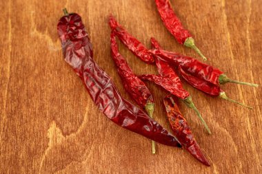 Güneşte kurutulmuş acı biber kabukları ahşap zemin üzerine yığılmış.