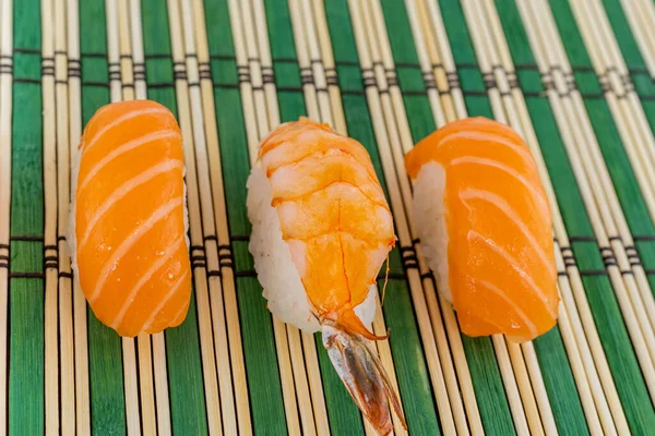 Trzy Sushi Świeże Łososie Tradycyjne Krewetki Zielonym Tle — Zdjęcie stockowe