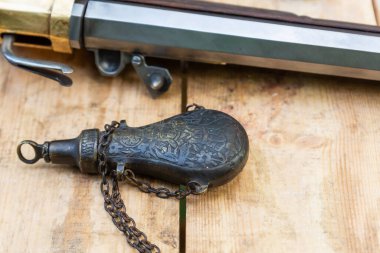 Eski tip demir barut kutusu bir tüfeğin arka planında duruyordu.