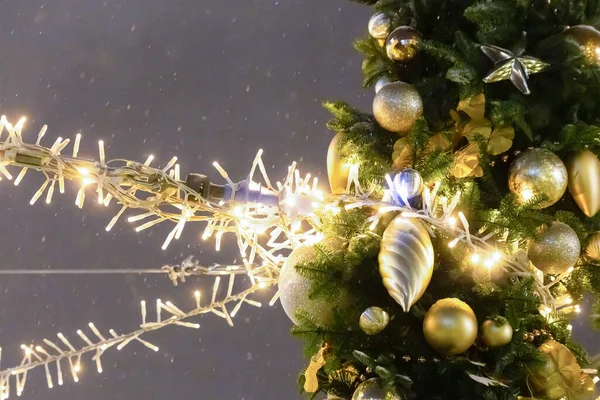 christmas decoration fair bright garland and arch of fir branches and golden ball on a dark background