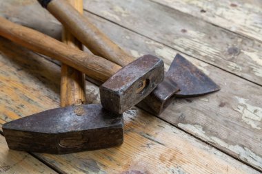 Eski tahtaların üzerinde üç adet balta ve çekiç var.
