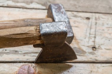 Balta, çekicin arka planıyla tahtalar arasındaki boşluğa sıkışmış.