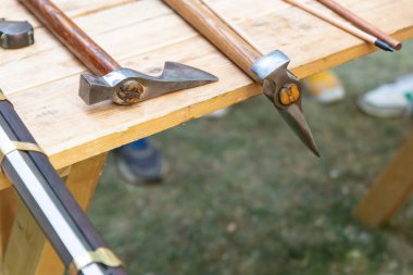 Uzun saplı bir balta ve masaya istiflenmiş bir tüfek.