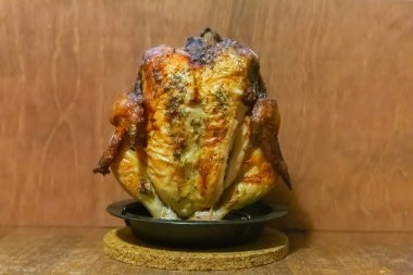 Kızarmış tavuk, bütün bir kuş, koyu bir arka planda duruyor lezzetli ve iştah açıcı.