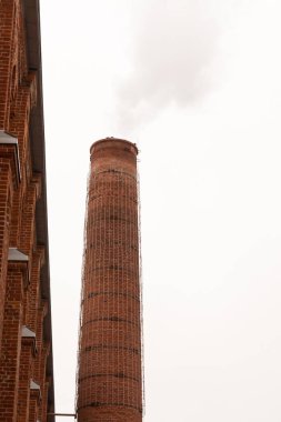 Gökyüzüne karşı dikey olarak eski bir fabrikada tuğla boru kopyalama alanı