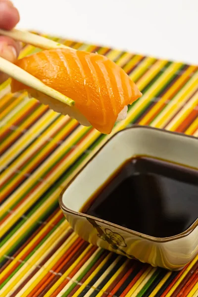 Sushi Nigiri Łosoś Nad Sosem Sojowym Tle Wielobarwnej Maty Bambusowej — Zdjęcie stockowe