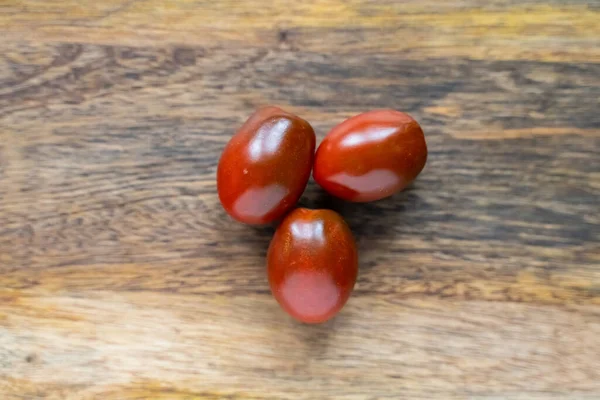 Tres Tomates Color Rojo Oscuro Sobre Fondo Madera Cerca —  Fotos de Stock