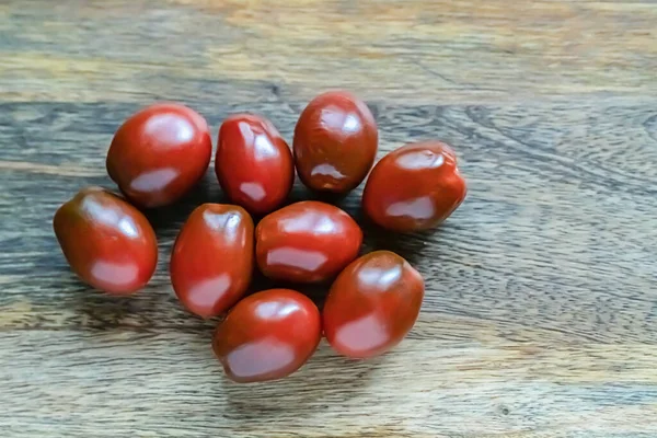 Dispersão Tomates Vermelhos Escuros Uma Superfície Cinza Madeira Perto — Fotografia de Stock