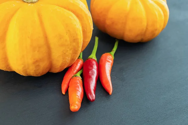 Par Calabaza Naranja Chiles Rojos Sobre Fondo Negro —  Fotos de Stock