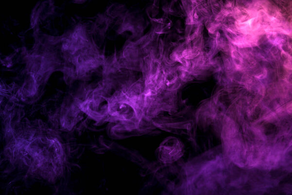 Pink and  blue cloud of smoke of  black isolated background. Background from the smoke of vap