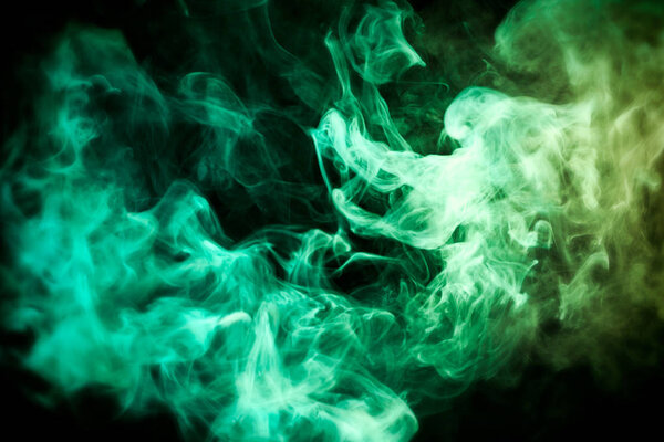 Green and  yellow cloud of smoke of  black isolated background. Background from the smoke of vap