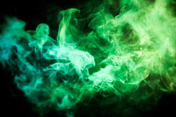 Green and yellow cloud of smoke of black isolated background. Background from the smoke of vap