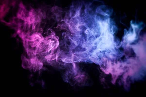Pink, purple and  blue cloud of smoke of  black isolated background. Background from the smoke of vap