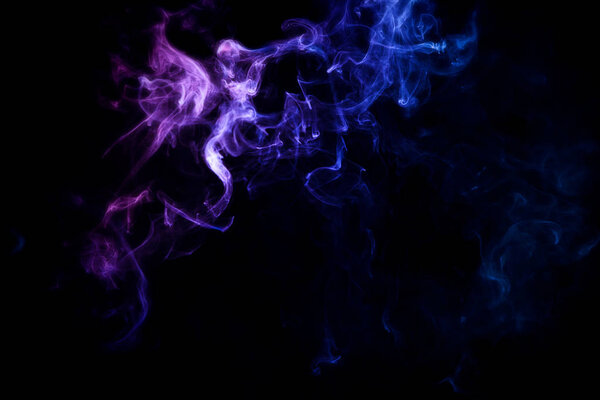 Dense multicolored smoke of pink, blue and purple colors on a black isolated background.