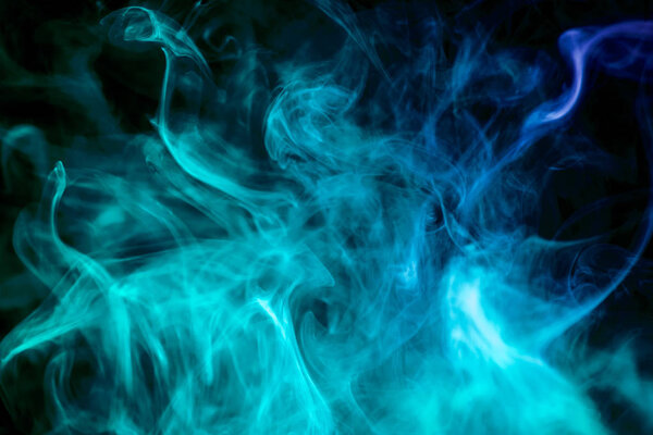 Dense blue smoke on a black isolated background. Background of smoke vap