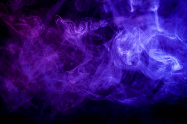 Dense blue smoke on a black isolated background. Background of smoke vap