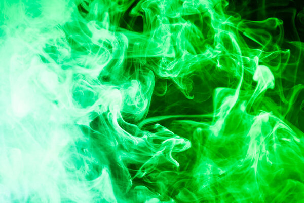Thick green smoke on a black isolated background. Background from the smoke of vap