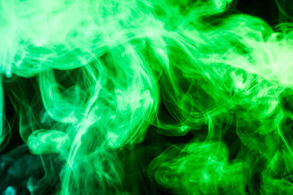 Thick green smoke on a black isolated background. Background from the smoke of vap