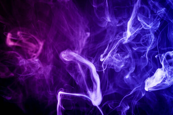 Thick colorful blue and pink smoke on a black isolated background. Background from the smoke of vap