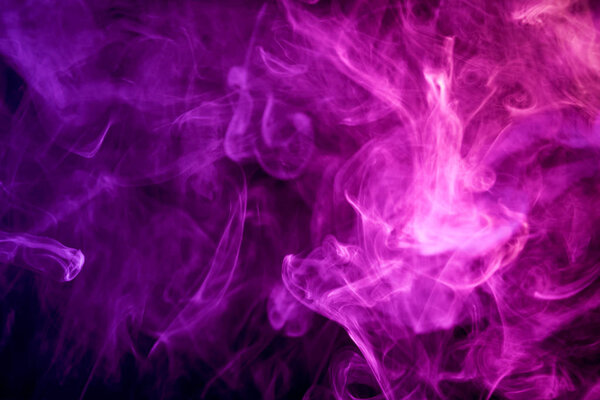 Thick colorful blue and pink  smoke on a black isolated background. Background from the smoke of vap