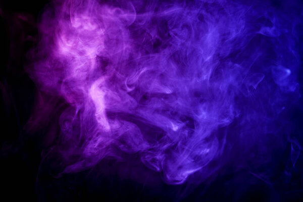 Thick colorful blue and pink smoke on a black isolated background. Background from the smoke of vap